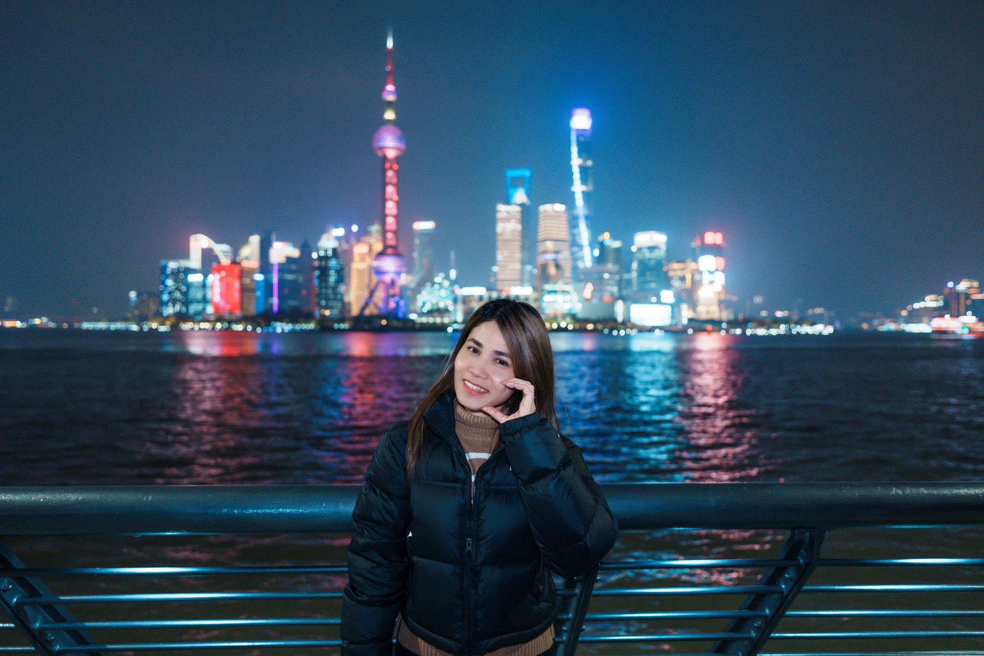 woman traveler visiting in Shanghai, China. Happy Female Tourist sightseeing Shanghai view of Lujiazui in The Bund of Shanghai at night. landmark and popular for tourism attractions. Vacation concept