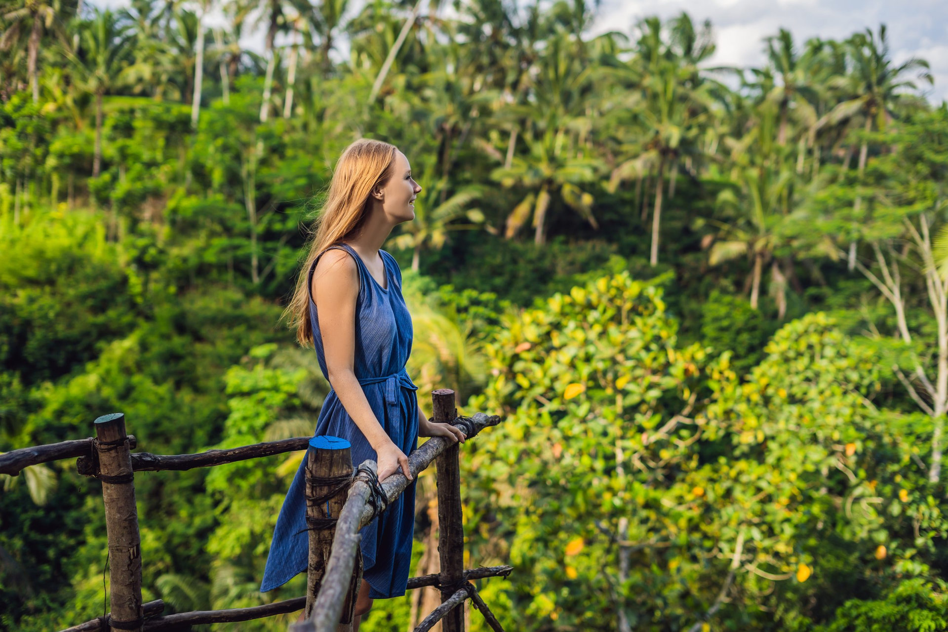 Young woman traveler on view point in the background of a jungle, Bali, Indonesia.