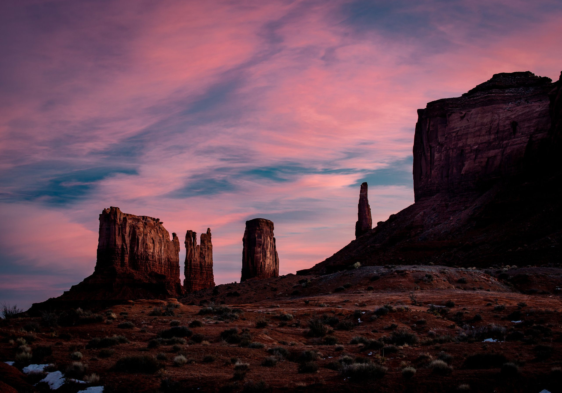 Western buttes around Monument Valley located near the border of Utah and Arizona. The Valley of The Gods national area comes to life in the soft pink glow of the morning sun light