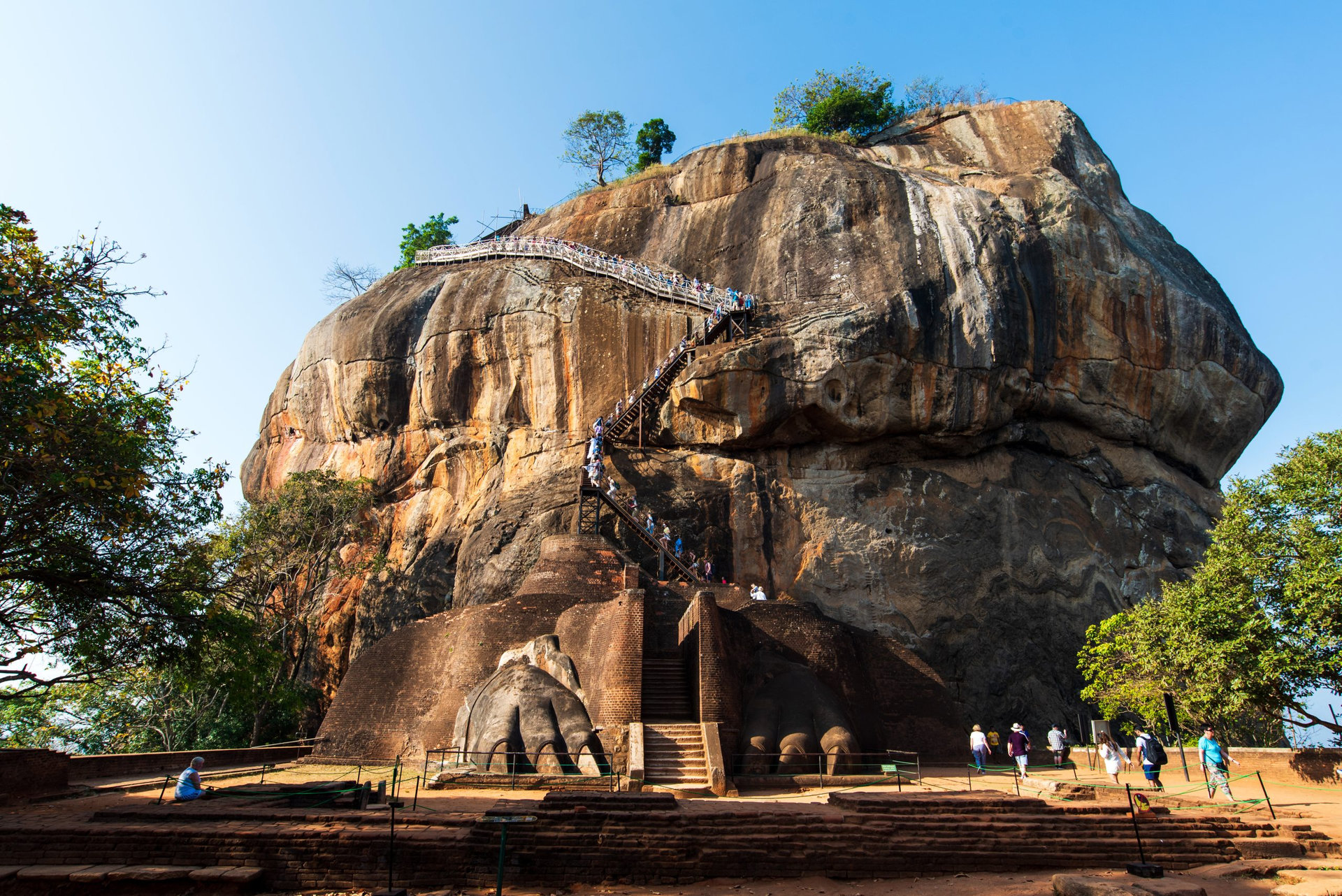 Sigiriya, Sri Lanka - March 31, 2019: Sigiriya ancient rock fortress in Sri Lanka with tourists climbing the stairs on a sunny day