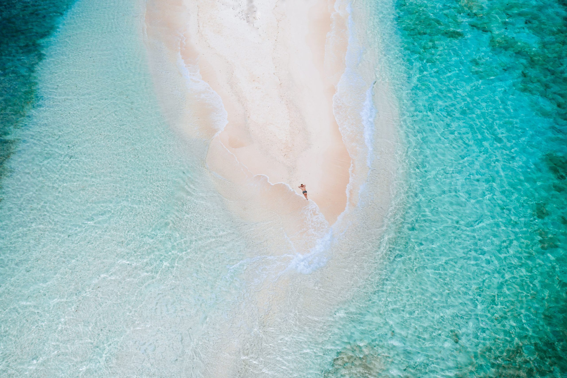 Naked island view from the sky. Man relaxing taking sunbath on the beach.shot taken with drone above the beautiful scene. concept about travel, nature, and marine landscapes