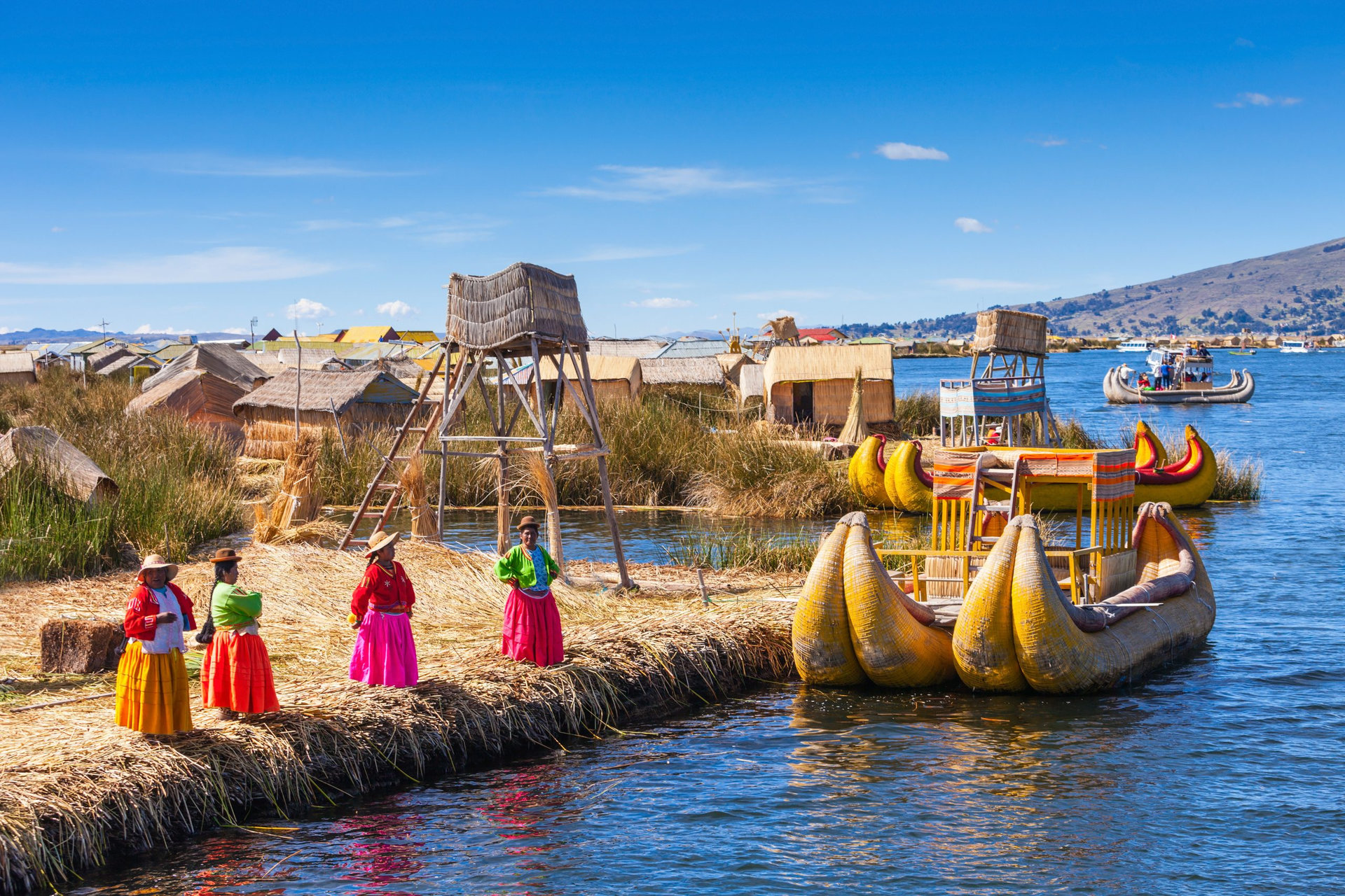 PUNO, PERU - MAY 14, 2015: Unidentified women in traditional dresses welcome tourists in Uros Island.