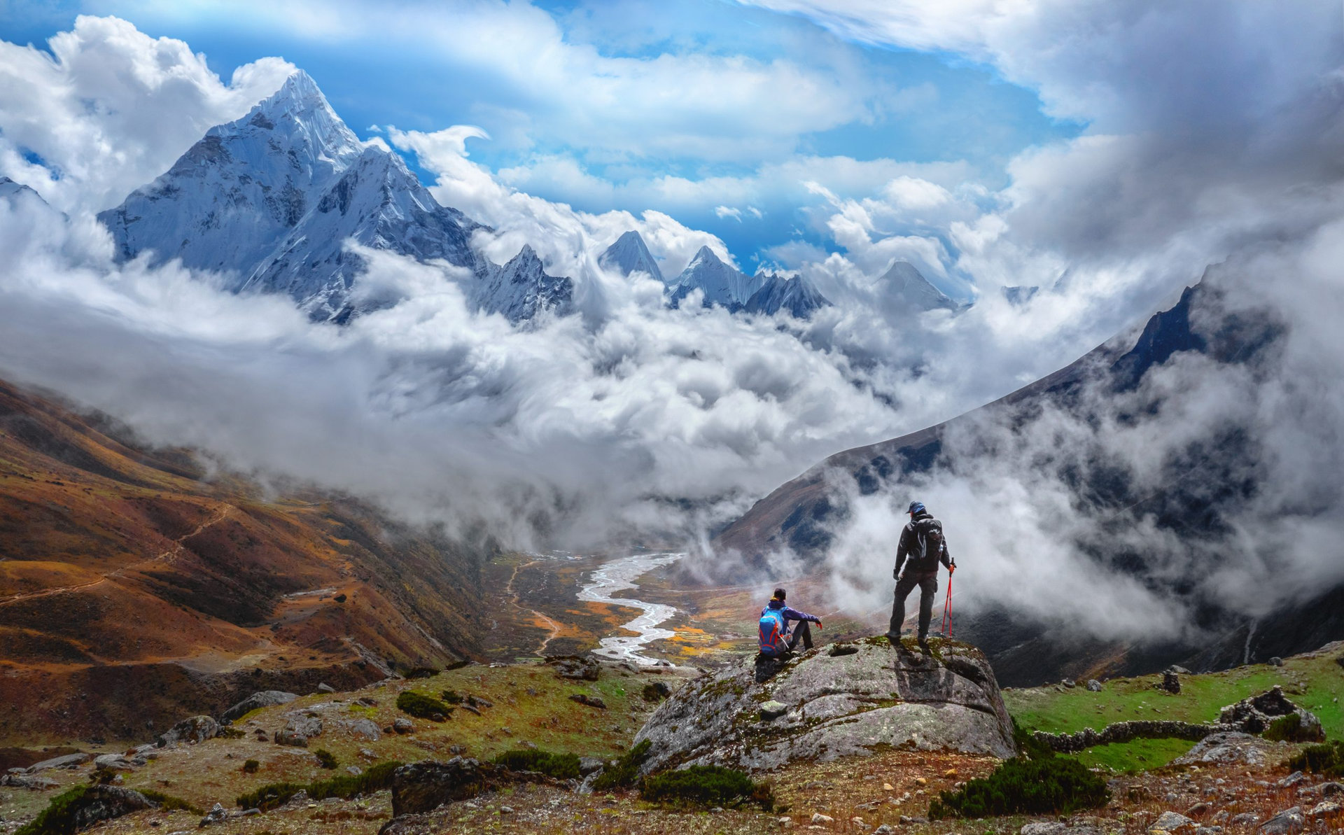 Active hikers hiking, enjoying the view, looking at Himalaya mountains landscape.Tracking to Everest base camp valley with Ama Dablam view. Travel sport lifestyle concept