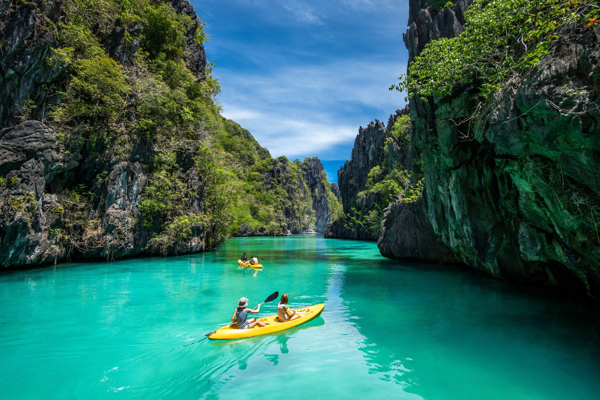 El Nido, Palawan, Philippines - May 27, 2017: Tourists on kayaks exploring the natural sights around El Nido on a sunny day in Palawan Island, Philippines.