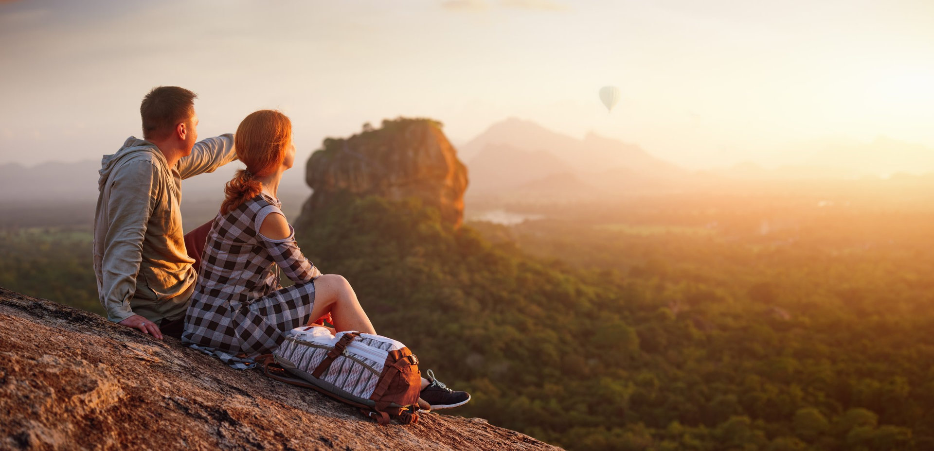 couple travelers watch a beautiful sunset near the famous rocky plateau Lion peak, Sigiriya. Sri Lanka