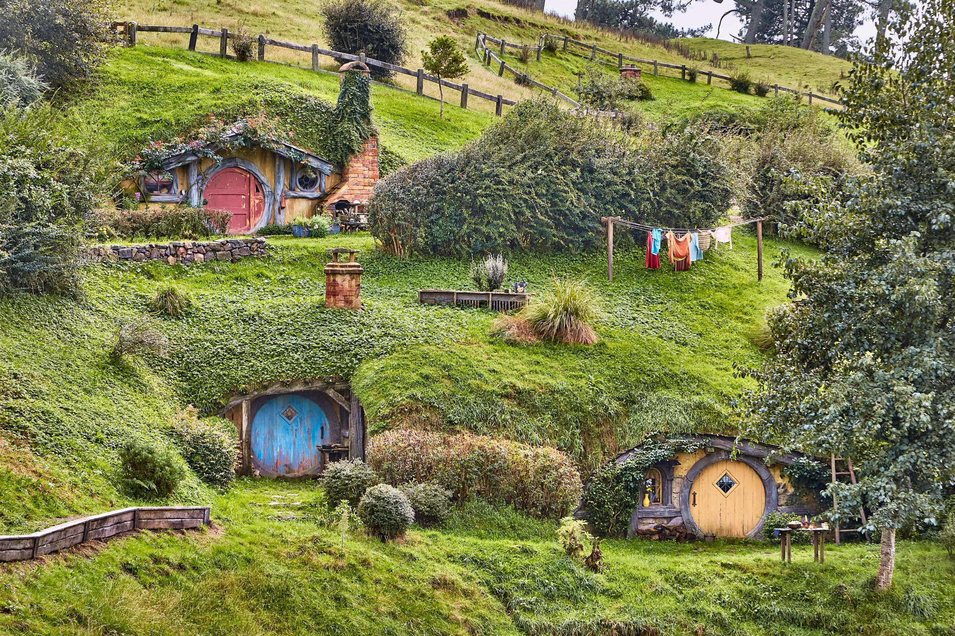 MATAMATA, NEW ZEALAND - CIRCA 2016: Movie set for the Lord of The Rings and The Hobbit. Hobbit holes in the hillside of the Shire, circular doors