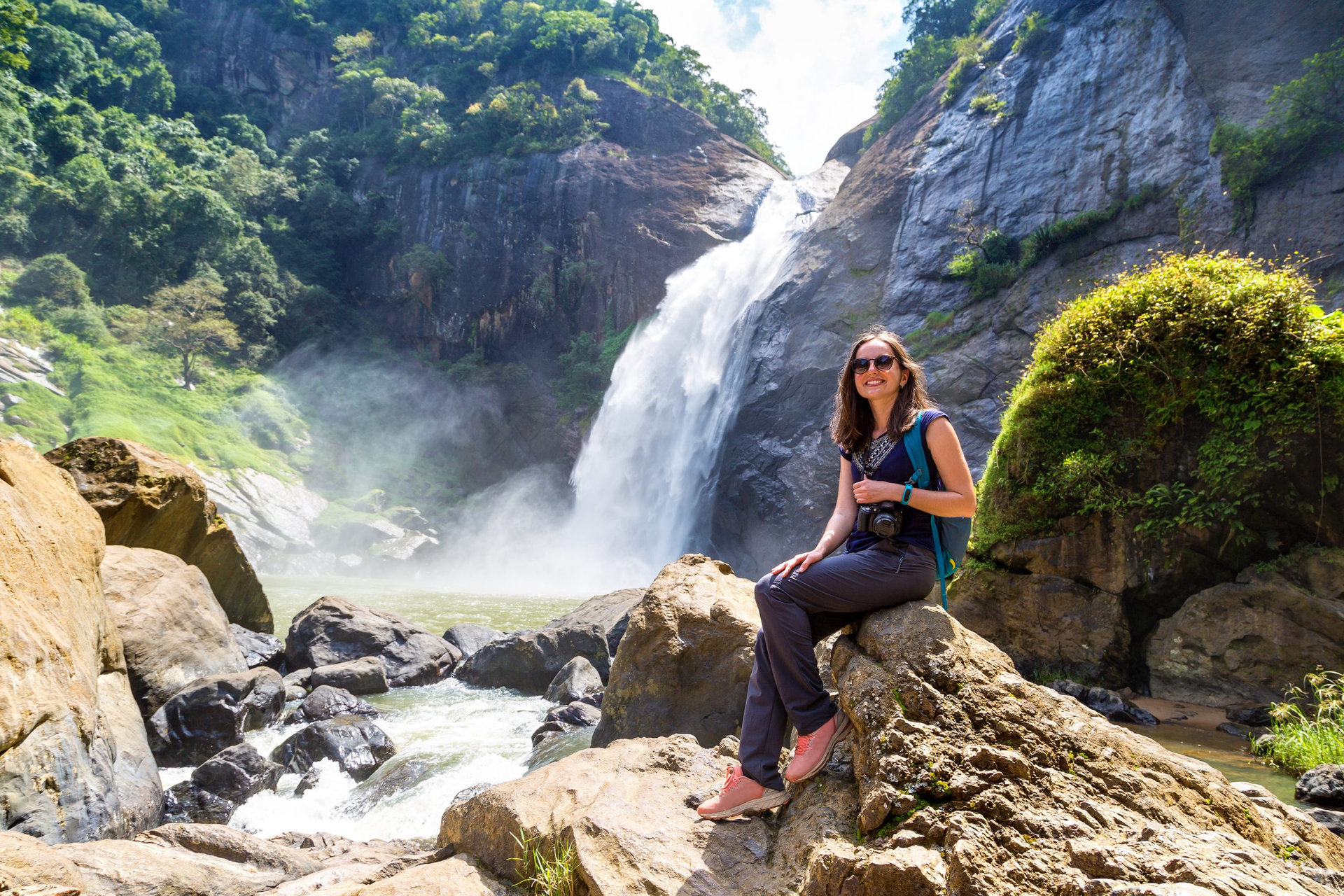 Woman tourist and Dunhinda waterfall in a sunny day in Sri Lanka