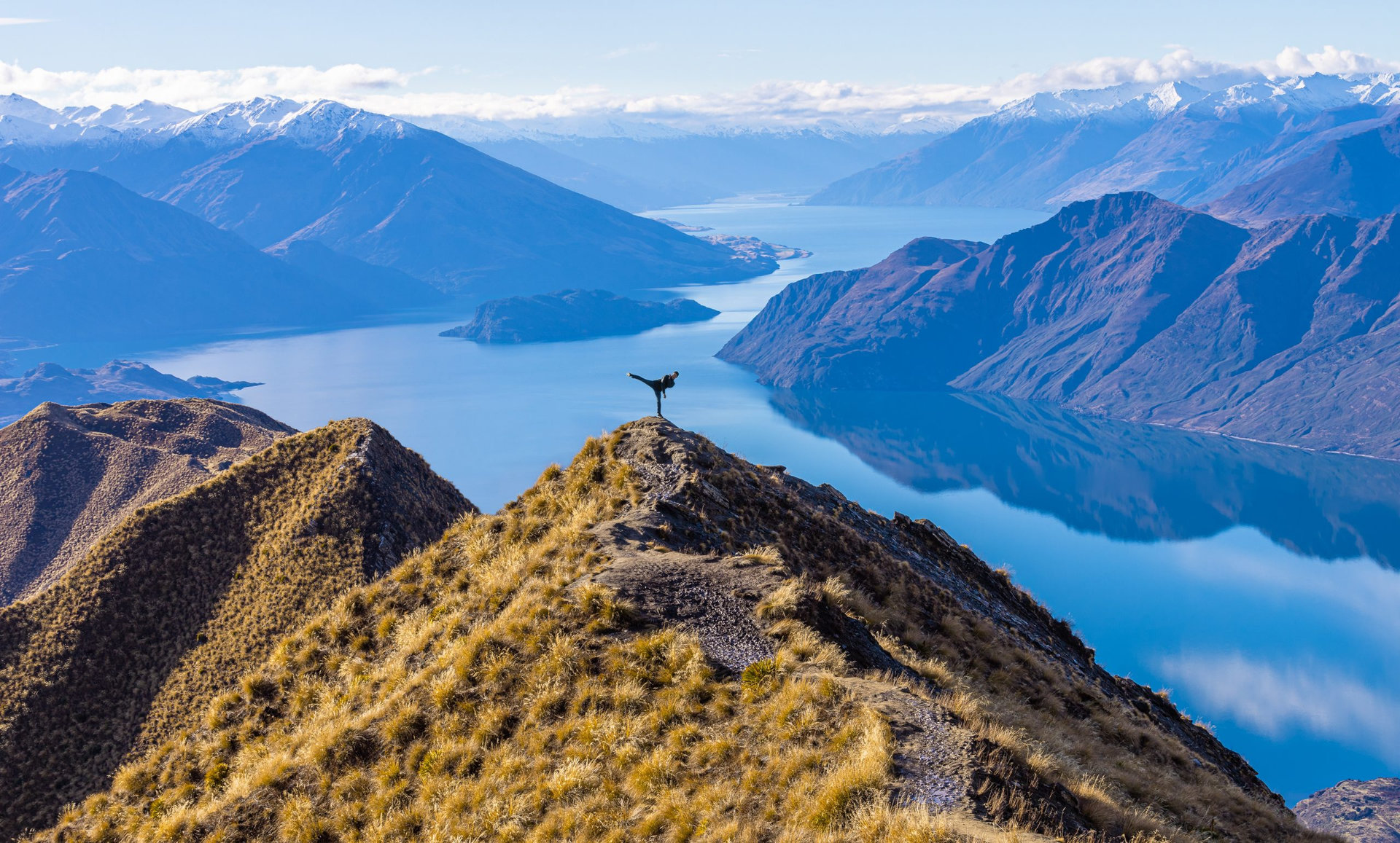 Asian tourist practicing martial arts side leg kick at Roy's Peak Lake Wanaka New Zealand