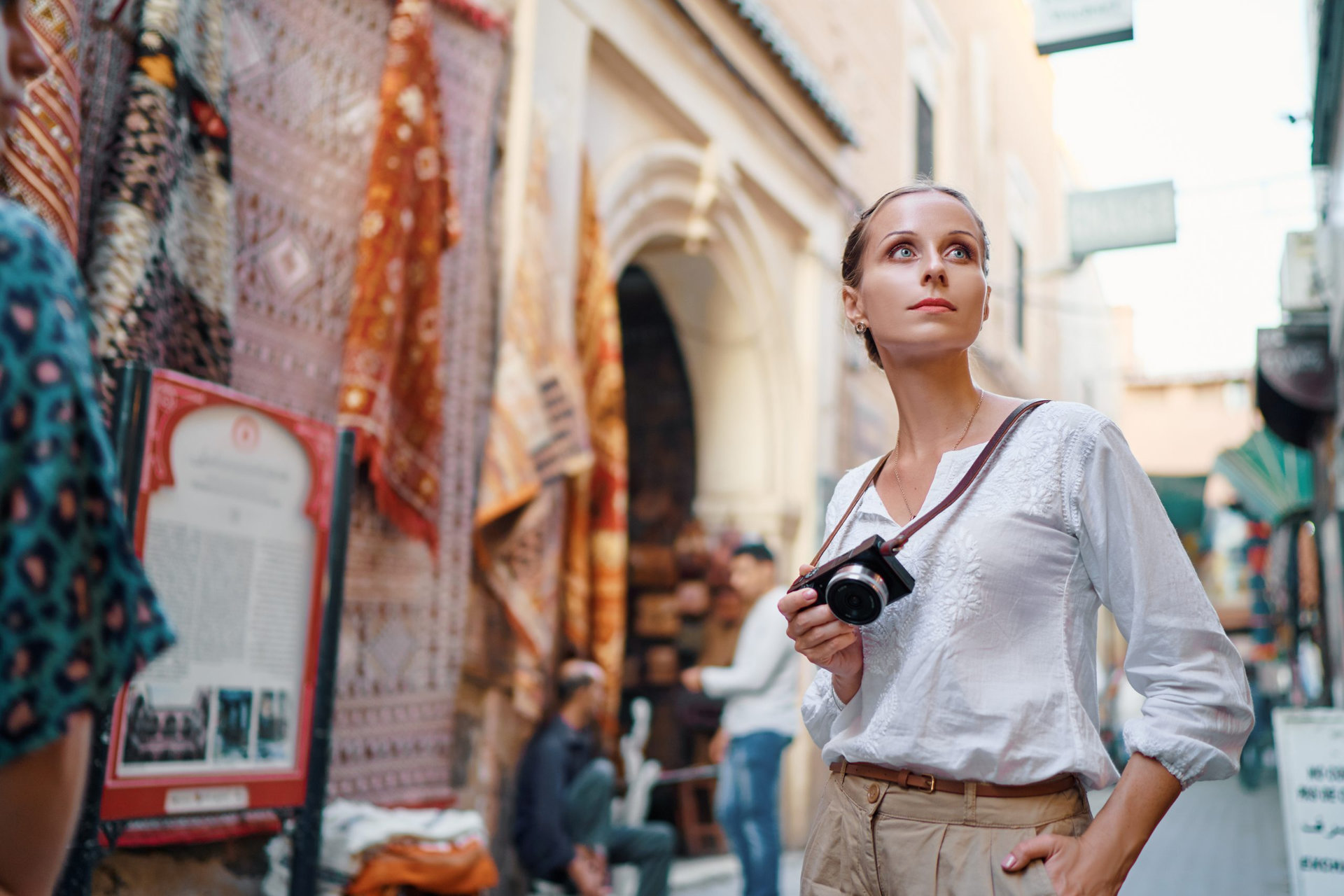 Tourism and technology. Happy young woman taking photo of Marrakesh old town. Traveling by Morocco.