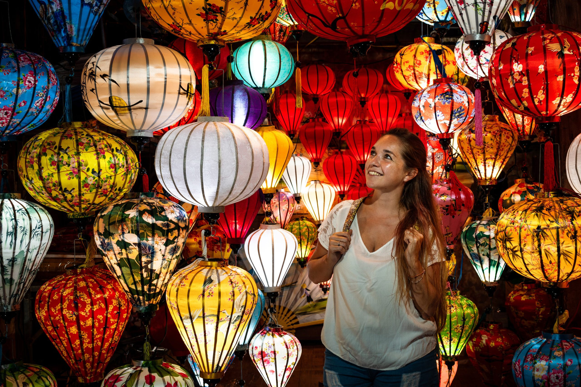 Mujer viajera disfrutando de lámparas coloridas del mercado nocturno de la ciudad de Hoi An, en Vietnam