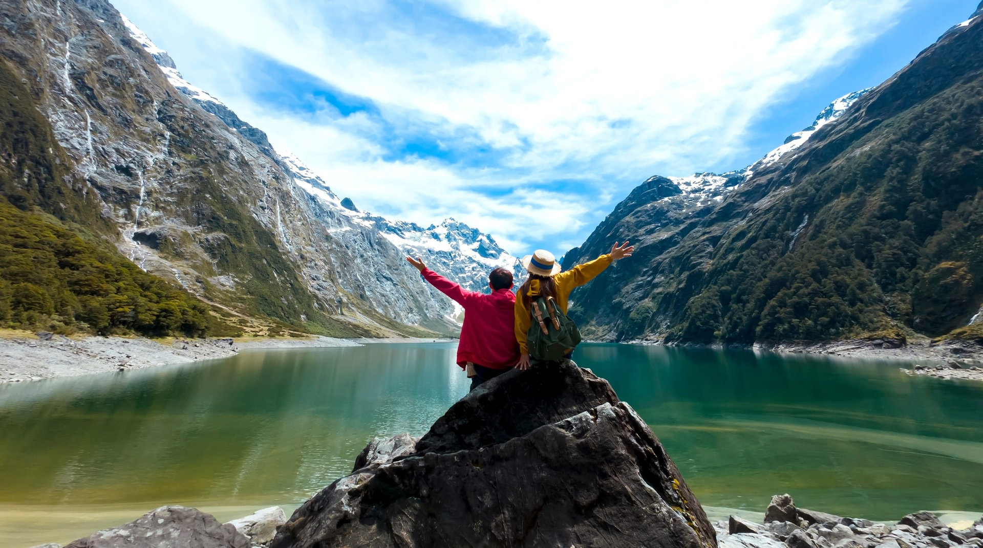 Travelers couple team look on the mountain landscape. Travel and active life concept as Adventure travel in the mountains region in lake marian fiordland national park