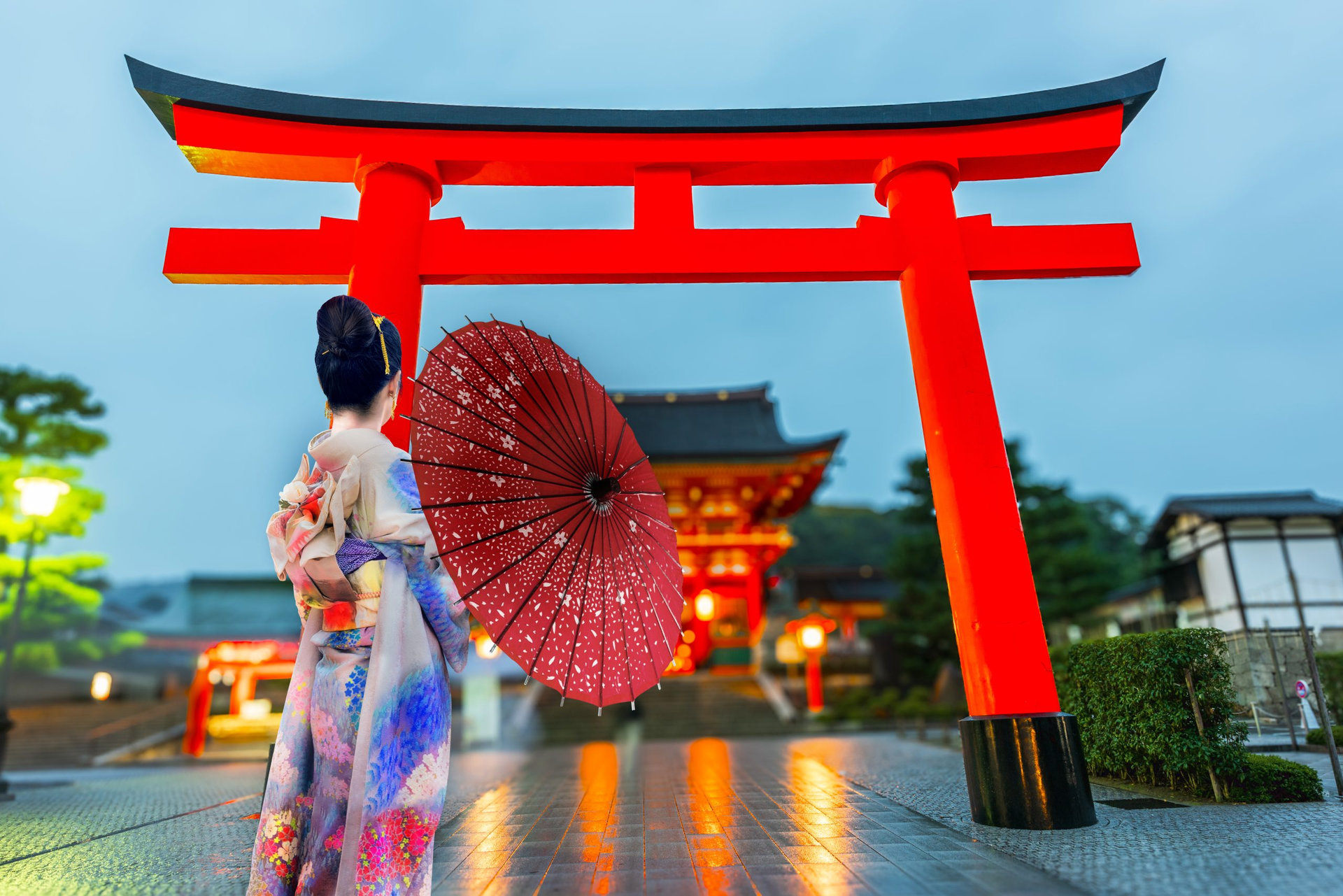 Young woman traveling at Fushimi Inari taisha Shrine at sunrise, landmark and popular for tourists attractions in Kyoto,Japan