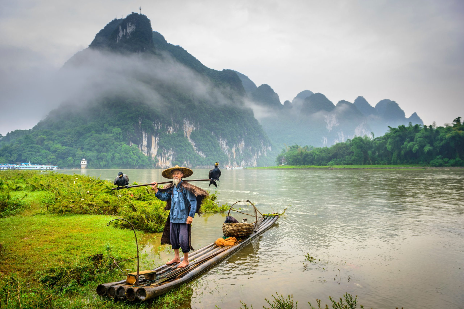 Cormorant fisherman and his birds on the Li River in Yangshuo, Guangxi, China.