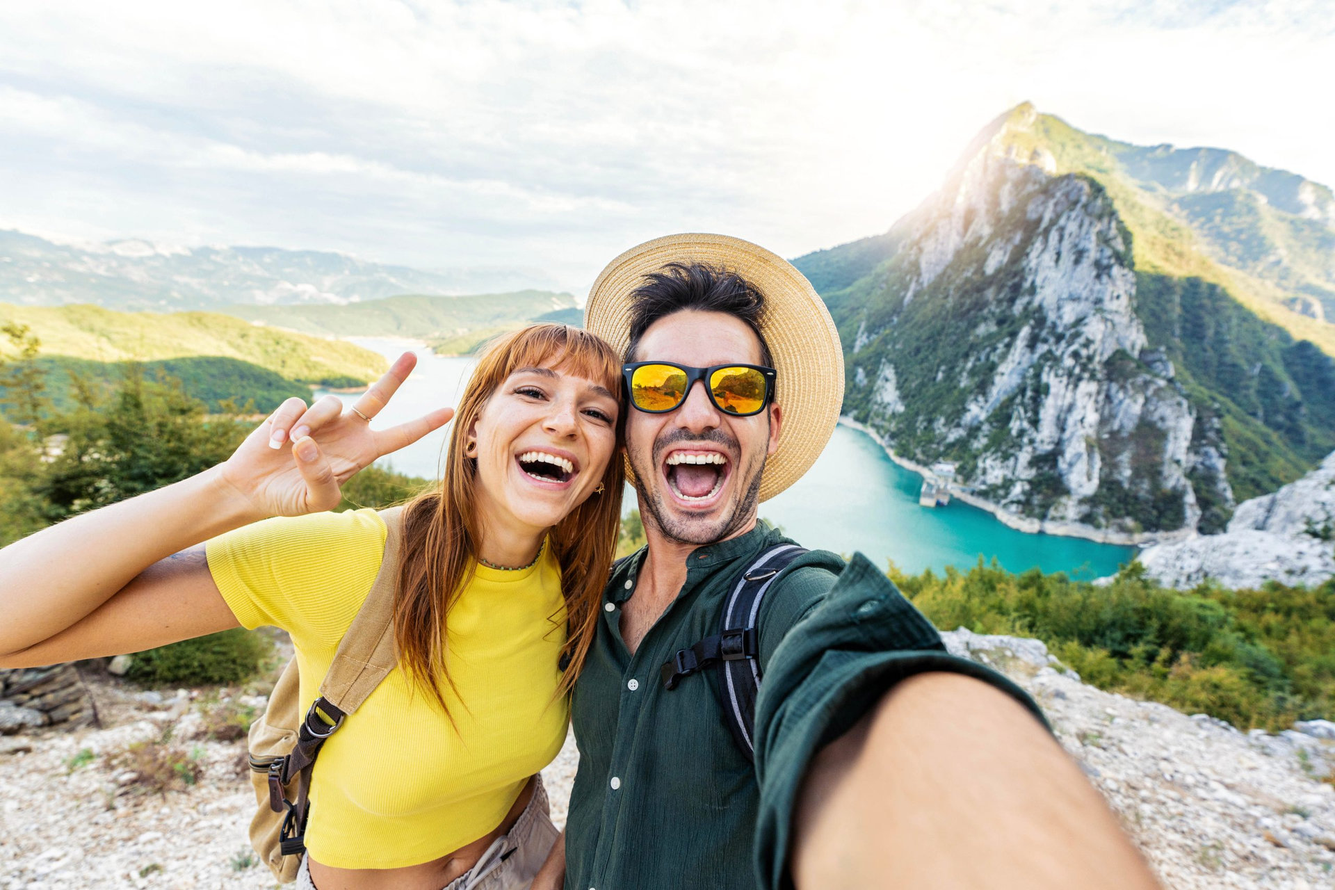 Happy couple taking selfie pic with smart mobile phone on top of the mountain - Young hikers climbing the cliff - Sport, technology and travel life style concept