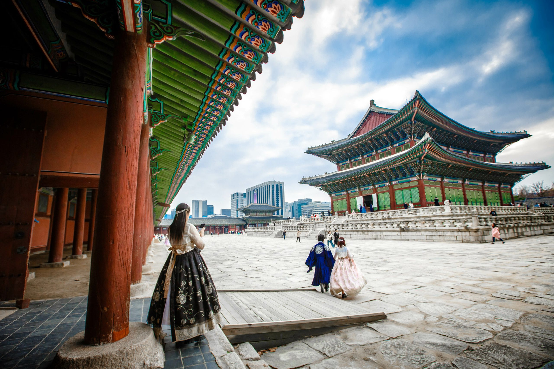 Tourists in national clothes walk in Gyeongbokgung Palace
