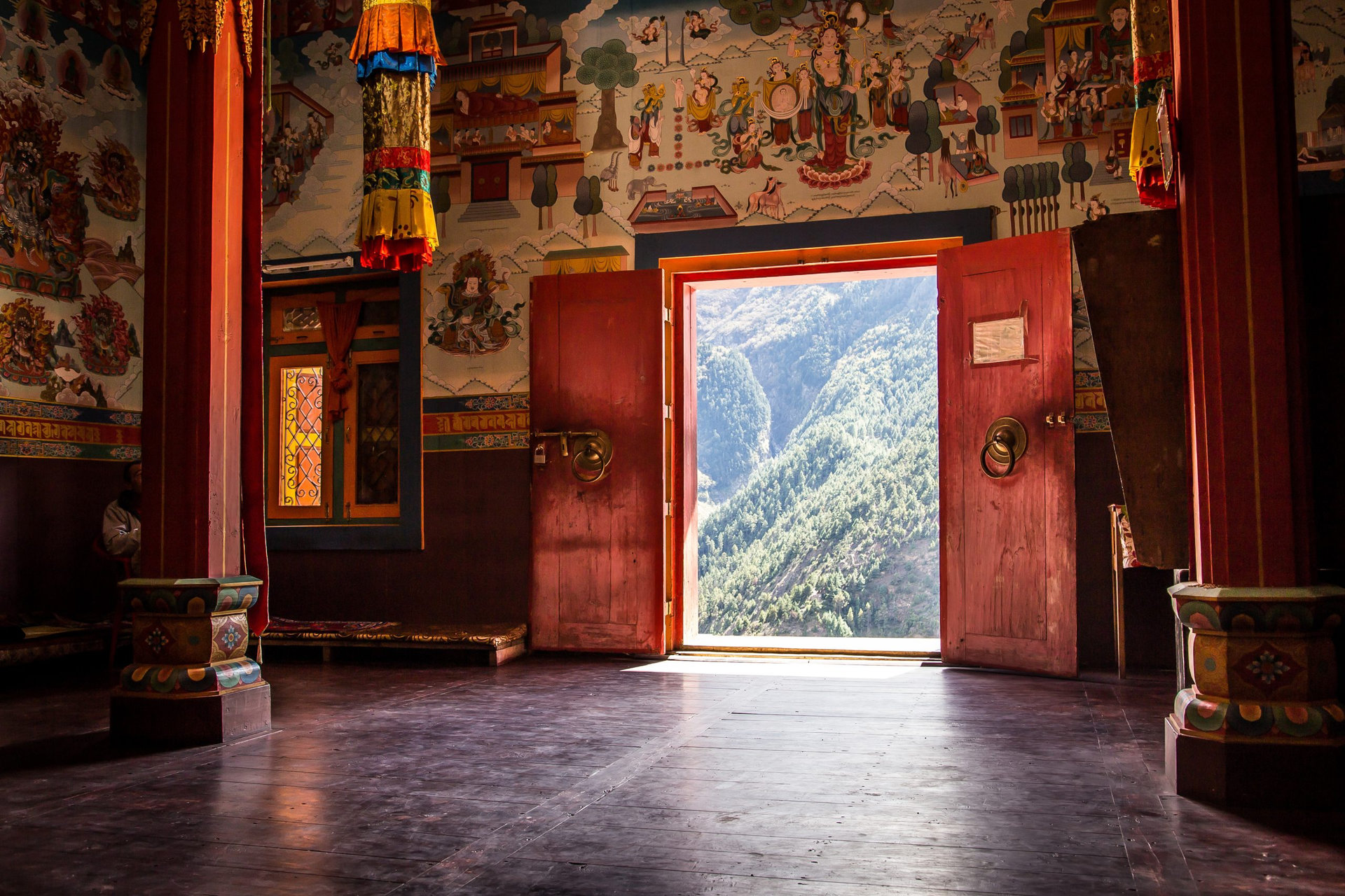Buddhist monastery interior with an open door to the mountains