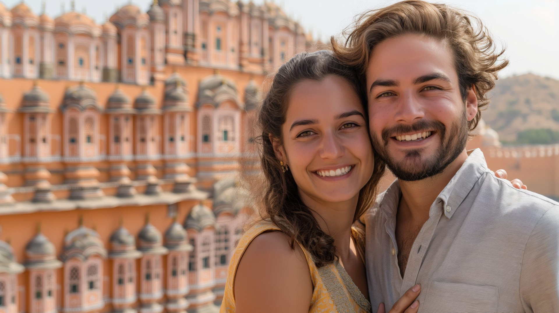 A Joyful Caucasian couple poses for a photograph in front of Jaipur's iconic Hawa Mahal, Copy space